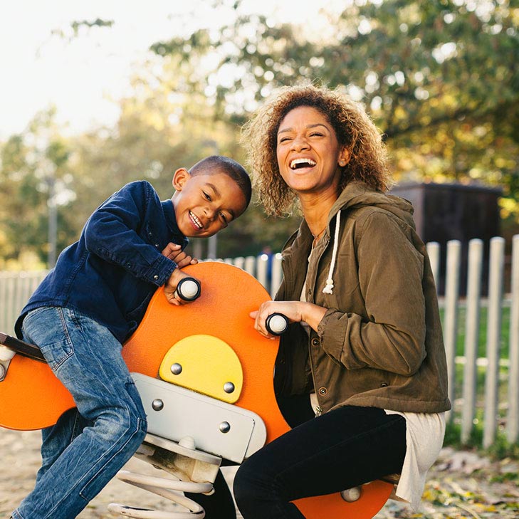 Mother and young son playing on playground