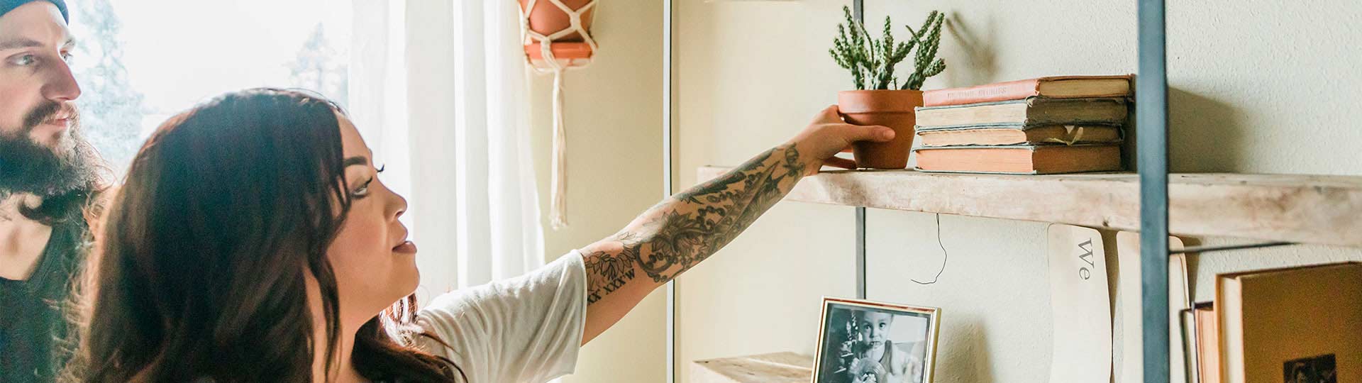 Woman placing a plant on a shelf